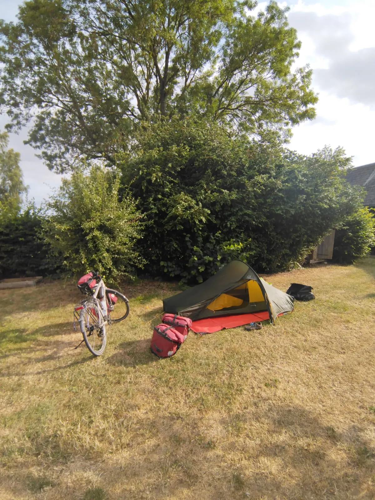 Le vélo et la tente installés dans le camping à la ferme